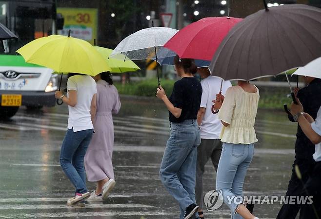 장맛비 내리는 광주 (광주=연합뉴스) 조남수 기자 = 7일 광주 북구청 앞 도로에서 시민들이 내리는 장맛비에 우산을 쓰고 걷고 있다. 2023.7.7 iso64@yna.co.kr