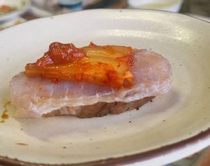 Hongeo samhap, a famous trio of fermented skate fish, steamed pork and kimchi [YIM SEUNG-HYE]