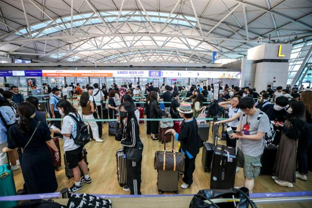 인천국제공항 제1터미널 출국장이 휴가철을 맞아 외국으로 떠나려는 여행객들로 붐비고 있다. 인천공항공사는 스마트패스를 도입하면 탑승 수속에 드는 시간이 많이 줄어들 거라고 홍보했지만 사전 등록을 위해 출시된 앱에서 첫 날부터 오류가 발상했다. 뉴시스