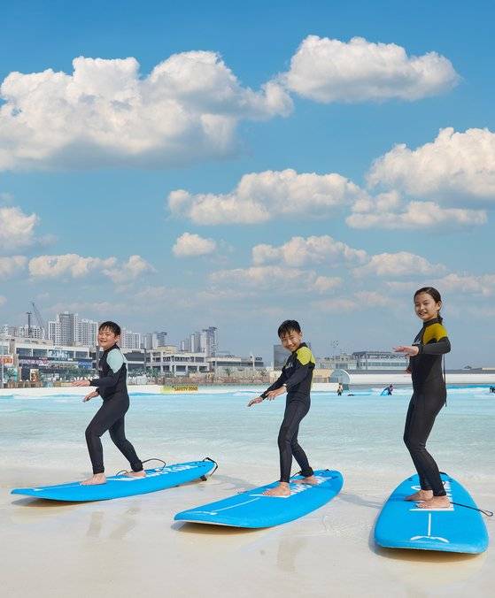 여름철 대표 레저 스포츠로 자리 잡고 있는 서핑을 배워보기 위해 국내 최대 규모의 야외 인공서핑장 웨이브파크를 찾은 한재민·유정현·박재인(왼쪽부터) 학생기자 파도 위를 시원하게 가로지르며 서핑의 매력을 알아봤다.