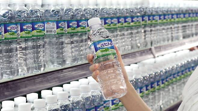 A person picks up a bottle of Jeju Samdasoo in a supermarket. (Jeju Special Self-Governing Province Development Co.)