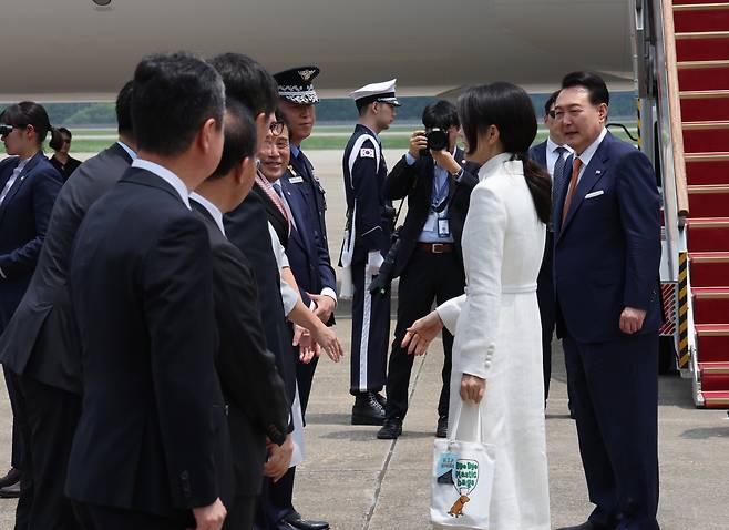 윤석열 대통령과 함께 리투아니아에서 열리는 북대서양조약기구(NATO.나토) 정상회의 참석과 폴란드 방문에 나서는 김건희 여사가 10일 성남 서울공항에 도착, 환송객들과 인사하고 있다. 김 여사는 이날 바이바이 플라스틱 백이라는 문구가 적힌 에코백에 힙 코리아(HIP KOREA)라고 적힌 키링(열쇠고리)을 매달았다. [연합]