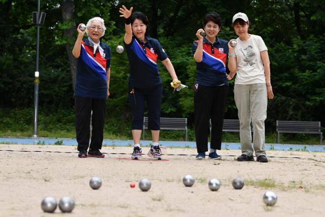서초 페탕크 클럽 회원들이 6월 20일 서울 서초구 매헌시민의숲에서 목표 공인 뷧(빨간 공)을 향해 쇠공(불)을 던지고 있다. 안다은 인턴기자