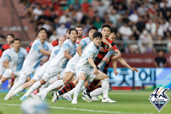 Ulsan Hyundai vie for the ball with the Pohang Steelers during the east coast derby on Saturday at the Steelyard in Pohang, North Gyeongsang. Ulsan won the game 1-0, extending their lead at the top of the K League.  [YONHAP]