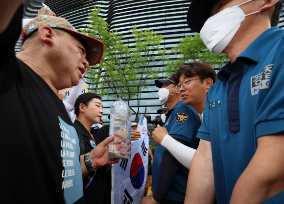 후쿠시마 바닷물 - 촛불연대 회원들이 8일 오후 서울 종로구 일본대사관 앞에서 직접 후쿠시마 원전 인근 해상에서 떠온 바닷물을 일본대사관 측에 전달하려다 경찰에 가로막히고 있다. 2023.7.8 연합뉴스