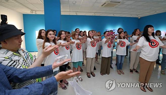 우크라이나 소녀 합창단과 산불 피해 화가의 만남 (강릉=연합뉴스) 유형재 기자 = 전쟁의 참화 속에 '2023 강릉 세계합창대회'에 참가한 우크라이나 보그닉 합창단이 11일 오후 강릉시립미술관에서 지난 4월 강릉에서 발생한 대형산불로 작업실과 작품을 잃은 '자폐화가' 이장우씨와 만나 서로를 위로하고 있다. 2023.7.11 yoo21@yna.co.kr