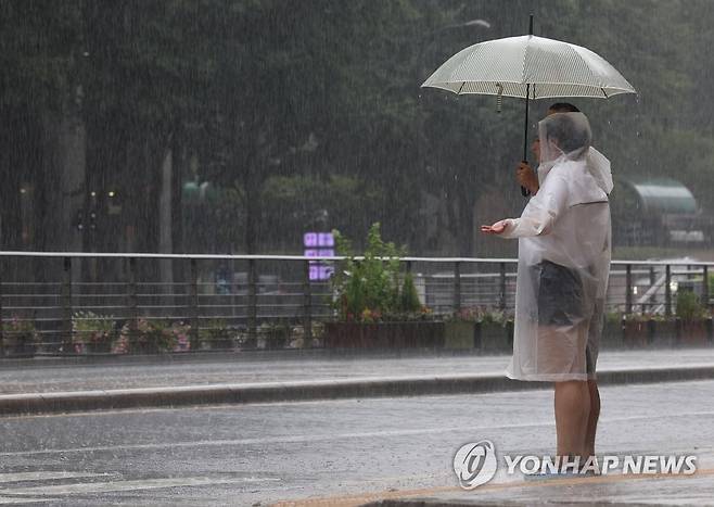 '서울에도 많은 비' (서울=연합뉴스) 이지은 기자 = 서울 전역에 호우경보가 내려진 11일 오후 서울 시내에서 우비를 입은 외국인들이 횡단보도 신호가 바뀌기를 기다리고 있다. 2023.7.11 jieunlee@yna.co.kr