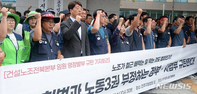 [전주=뉴시스] 김얼 기자 = 민주노총 전북본부 관계자들이 12일 전북 전주시 전주지방법원 앞에서 건설노조 전북본부 임원 영장 발부 규탄 기자회견을 열고 구호를 외치고 있다. 2023.07.12. pmkeul@nwsis.com