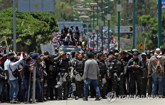 경찰관 등 둘러싼 멕시코 폭력 시위대 (칠판싱고[멕시코] EPA=연합뉴스) 10일(현지시간) 멕시코 게레로주 칠판싱고에서 폭력 시위대가 경찰관 등을 억류한 채 갱단 간부 2명 석방을 요구하고 있다. 2023.7.12