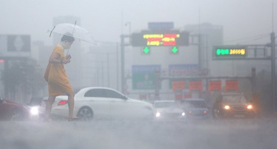 13일 비가 쏟아지는 서울 여의대로 횡단보도 위로 우산을 쓴 시민들이 지나고 있다. 연합뉴스