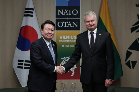 President Yoon Suk Yeol, left, shakes hands with Lithuanian President Gitanas Nauseda during their talks in Vilnius, Lithuania, on Wednesday. [JOINT PRESS CORPS]