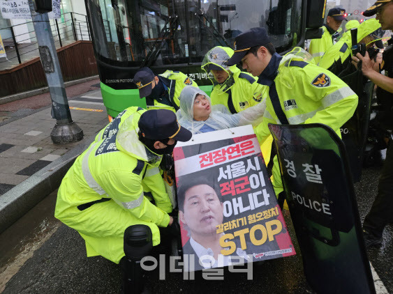 전국장애인차별철폐연대(전장연)이 14일 오전 서울 동작구 대방역 인근 버스정류장에서 버스 운행을 막아서는 기습 시위를 펼치자 경찰이 이를 제지하고 있다.(사진=이영민 기자)