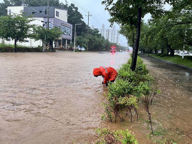 전북 14개 시·군 전역에 호우 특보가 내려진 14일 오전 군산시 사정동의 한 도로가 침수돼 소방대원들이 배수 작업 중이다. /전북소방본부 제공