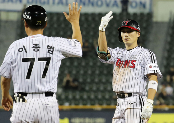 Shin Min-jae of the LG Twins, right, celebrates after hitting a single against the Hanwha Eagles during a game at Jamsil Baseball Stadium in southern Seoul on Wednesday.  [NEWS1]