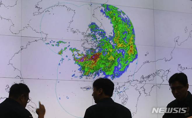 [서울=뉴시스] 김명원 기자 = 14일 오전 서울 종로구 정부서울청사 중앙재난안전상황실 서울상황센터에서 열리는 호우대처 상황 점검회의에 앞서 관계자들이 폭우에 따른 기상레이더 영상을 살펴보고 있다. 2023.07.14. kmx1105@newsis.com