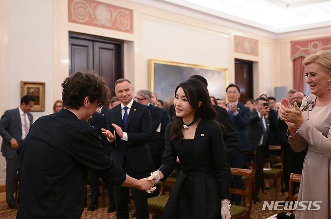 [바르샤바(폴란드)=뉴시스] 홍효식 기자 = 윤석열 대통령 부인 김건희 여사가 13일(현지시간) 바르샤바 대통령궁에서 열린 공식 만찬에서 피아노 연주자인 마테우시 두비엘을 격려하고 있다. (공동취재) 2023.07.14. yesphoto@newsis.com