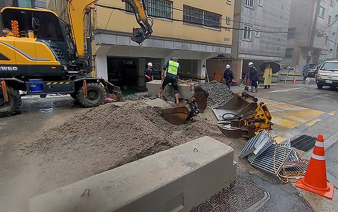 지난 13일 지난해 8월 일가족 3명이 참변을 당한 바로 앞도로에서 구청 관계자들이 빗물받이 응급 복구작업을 하고 있다.