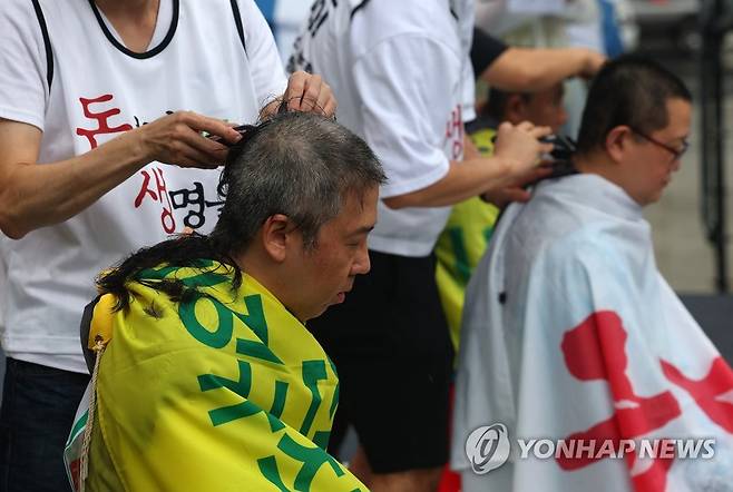 삭발투쟁 (부산=연합뉴스) 손형주 기자 = 14일 오후 부산 동구 부산역에서 열린 보건의료노조 부산지역본부 부산대병원지부 총파업 결의대회에서 노조 간부들이 삭발식을 하고 있다. 2023.7.14 handbrother@yna.co.kr