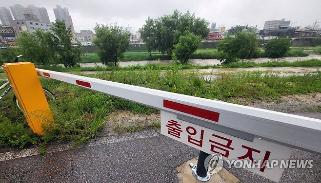 춘천 도심 산책로 많은 비에 통제 (춘천=연합뉴스) 많은 비가 내린 지난 13일 오후 강원 춘천시 도심 공지천 일대 산책로가 통제돼 있다. [연합뉴스 자료사진]