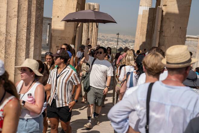 한 관광객이 햇볕을 가리기 위해 우산을 쓴 채 그리스 아테네의 아크로폴리스를 걷고 있다. /AP 연합뉴스