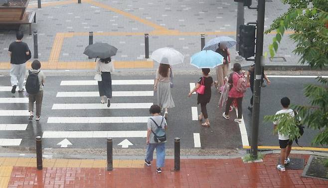 소나기가 내리는 가운데 우산을 쓴 시민들이 길을 지나가고 있다. ⓒ데일리안