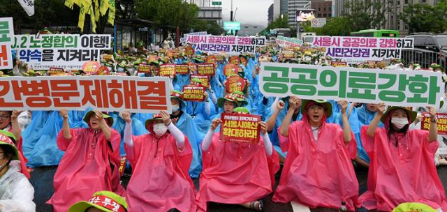 보건의료노조 조합원들이 14일 서울 중구 동화면세점 인근에서 열린 서울·경기지역본부 산별총파업대회에서 손팻말을 들고 있다. 윤서영 인턴기자