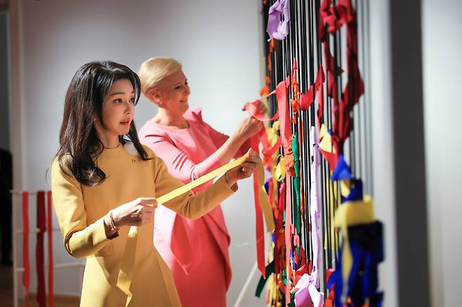 윤석열 대통령과 폴란드를 공식 방문 중인 김건희 여사가 13일(현지시간) 바르샤바의 와지엔키 박물관에서 프리다 칼로의 시그니처 색상을 사용해 리본을 구성하는 체험을 하고 있다. 대통령실제공