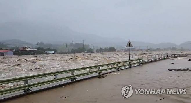 충북 괴산댐 만수위 넘어 (서울=연합뉴스) 사흘째 이어진 폭우로 15일 오전 충북 괴산군 칠성면에 있는 괴산댐이 만수위를 넘어 월류 중인 가운데 괴산댐 하류 지역이 침수돼 있다. 2023.7.15 [독자 제공. 재판매 및 DB 금지] photo@yna.co.kr