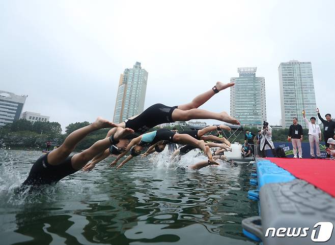 16일 오전 서울 송파구 롯데월드타워 일대에서 열린 '2023 롯데 아쿠아슬론 대회'에 출전한 참가자들이 석촌호수에서 수영을 하고 있다. 2023.7.16/뉴스1 ⓒ News1 신웅수 기자