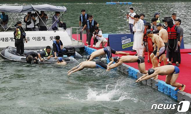 16일 오전 서울 송파구 롯데월드타워 일대에서 열린 '2023 롯데 아쿠아슬론 대회'에 출전한 참가자들이 석촌호수에서 수영을 하고 있다. (공동취재) 2023.7.16/뉴스1 ⓒ News1 신웅수 기자