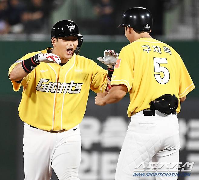 강속구를 받아쳐 안타를 친 유강남이 1루 베이스 코치 구자욱과 함께 환호하고 있다.