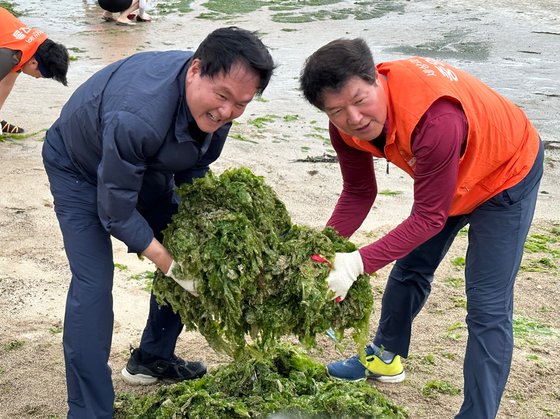 김희현 제주도 정무부지사(왼쪽)와 인채권 중앙홀딩스 사장이 수거한 구멍갈파래를 들어보이고 있다. 최충일 기자