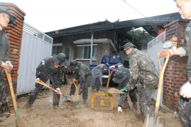 육군 2작전사령부 50사단 장병들이 15일 집중 호우로 인해 토사가 밀려든 경북 예천군 감천면 가옥에서 복구 작업을 벌이고 있다. 연합뉴스