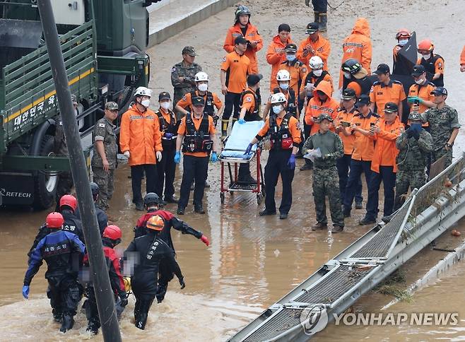 오송 지하차도 추가 희생자 수습 (청주=연합뉴스) 김주형 기자 = 16일 미호천 제방 유실로 침수된 충북 청주시 오송읍 궁평2지하차도에서 119 구조대원들이 시신으로 발견된 실종자를 수습하고 있다.  2023.7.16 kjhpress@yna.co.kr