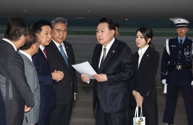 리투아니아·폴란드·우크라이나 순방을 마친 윤석열 대통령이 17일 성남 서울공항을 통해 귀국해 국민의힘 김기현 대표가 준비한 자료를 보며 박진 외교부 장관 등과 대화하고 있다. 연합뉴스