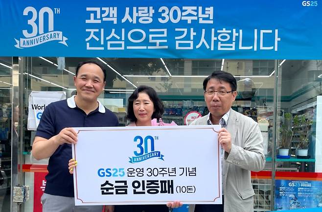 GS25는 지난 12일 GS25 신구로점을 30년 넘게 운영해 온 김정인자 경영주에게 30주년 기념 현판과 기념패를 증정했다. 사진은 김정인자 경영주(가운데)와 정재형 GS리테일 편의점사업부장(오른쪽), 김중관씨(김정인자 경영주 가족, 왼쪽)의 모습/사진제공=GS리테일