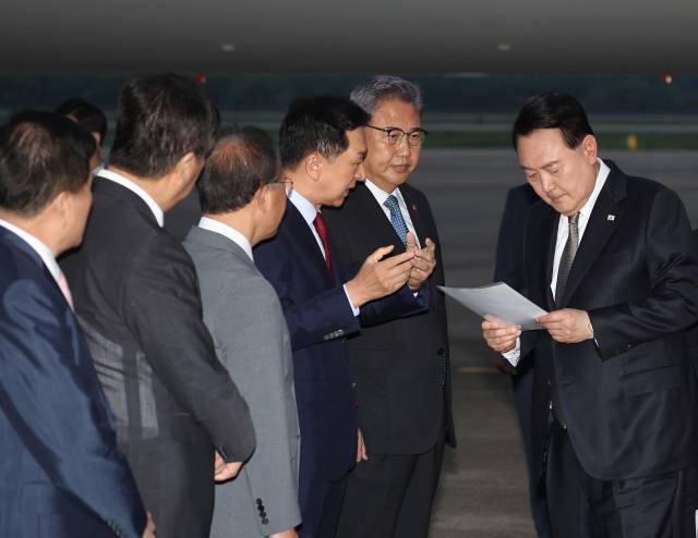 ▲리투아니아에서 열린 북대서양조약기구(NATO·나토) 정상회의와 폴란드·우크라이나 방문을 마친 윤석열 대통령이 17일 성남 서울공항을 통해 귀국해 국민의힘 김기현 대표가 준비한 자료를 보며 박진 외교부 장관 등과 대화하고 있다. ⓒ연합뉴스