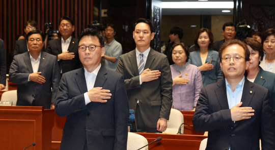 박광온 더불어민주당 원내대표와 의원들이 18일 서울 여의도 국회에서 열린 의원총회에서 국기에 대한 경례를 하고 있다. 연합뉴스.