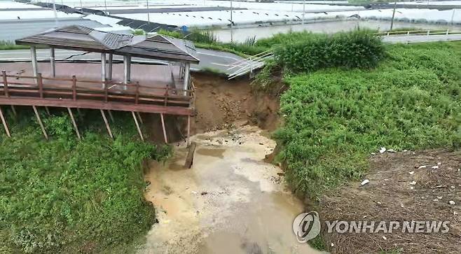 폭우로 무너져 내리는 논산 금강 제방 (논산=연합뉴스) 사흘째 이어지는 기록적인 폭우로 16일 오전 충남 논산시 성동면 우곤리 인근 금강 제방이 유실됐다. 사진은 금강과 우곤리 마을 사이에 놓인 제방이 무너져내리는 모습. 2023.7.16 [논산시 제공. 재판매 및 DB 금지] swan@yna.co.kr