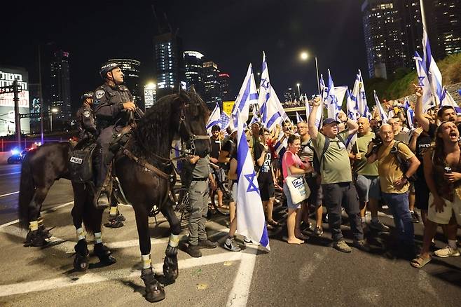 이스라엘 기마경찰대가 18일(현지시간) 텔아비브에서 고속도로를 점거한 반정부 시위대 해산을 시도하고 있다. AFP연합뉴스