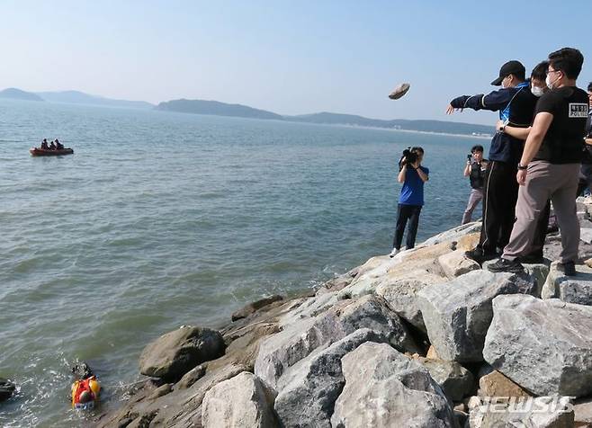 [인천=뉴시스] 김동영 기자 = 19일 오후 인천 중구 덕교동 잠진도 제방에서 아내를 바다에 빠트리고 돌을 던져 살해한 30대 남성이 사건 당시 상황을 재현하고 있다. 2023.7.19. dy0121@newsis.com