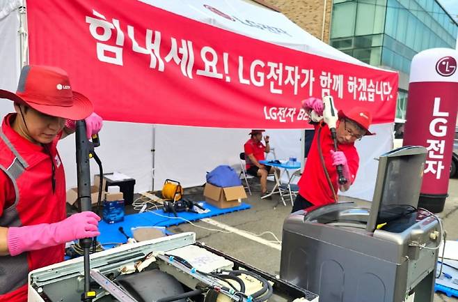 LG전자 임직원들이 집중호우로 침수된 가전제품을 점검, 수리하고 있다. 사진=LG그룹 제공