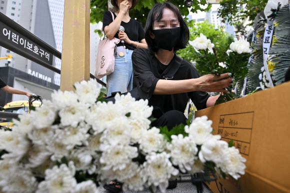 20일 서울 서초구 서이초등학교 앞에서 한 여성이 조화를 꺼내고 있다. 서울시교육청에 따르면, 지난 18일 오전 이 학교 1학년 담임인 A씨(23)가 극단적인 선택으로 사망하는 일이 발생했다. 2023.7.20 홍윤기 기자