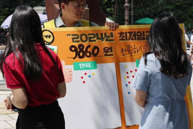 19일 서울마로니에공원에서 시민들이 이날 오전 결정된 최저임금에 관한 의견을 묻는 스티커 설문에 참여하고 있다. 최저임금위원회는 내년도 최저임금을 올해(9천620원)보다 2.5% 인상된 9천860원으로 결정했다. 연합뉴스