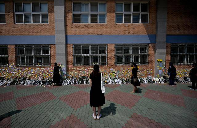 21일 서울 서초구 서이초등학교 한쪽 벽이 스스로 목숨을 끊은 초등학교 교사를 추모하는 메시지로 가득 찬 가운데 시민들이 고인을 추모하고 있다. 최주연 기자