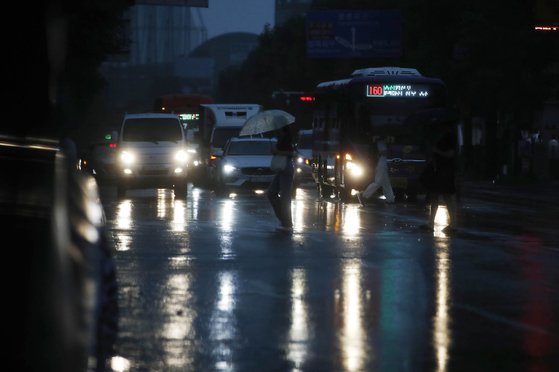 장맛비가 내리는 11일 광주 북구 전남대학교 후문 교차로를 지나는 차들이 어두워진 날씨에 전조등을 켜고 있다.사진 광주 북구=뉴스1