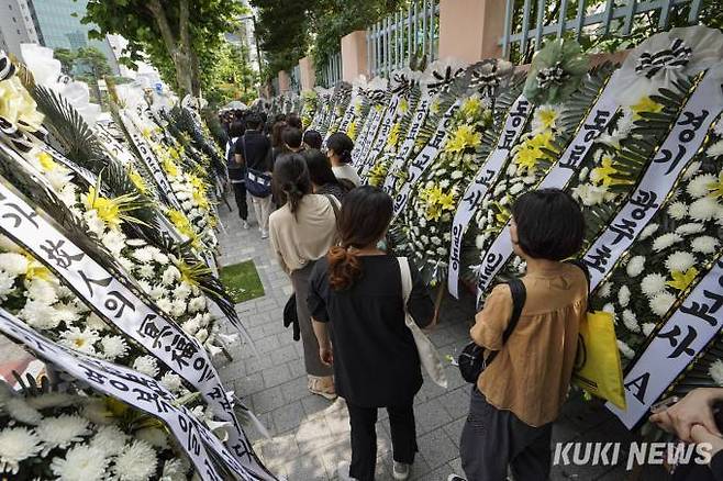 20일 오후 서울 서초구 한 초등학교에서 열린 추모행사에서 화환들 사이로 추모하러 오는 교사들과 시민들의 발길이 이어지고 있다.   사진=임형택 기자