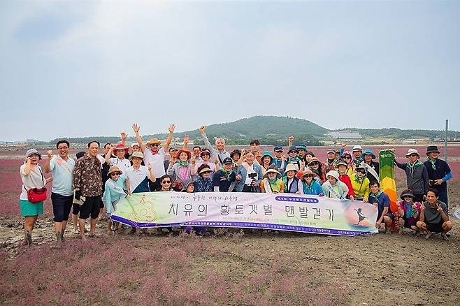 전남 무안의 황토갯벌에서 포즈를 취한 맨발로 걷는 사람들. 맨발걷기국민운동본부 무안지부 제공.