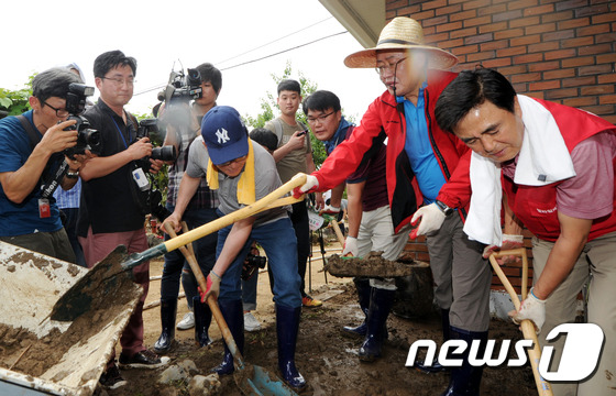 2017년 7월 19일 홍준표 자유한국당 대표가 충북 청주시 낭성면 한 마을에서 장화를 신은 채 삽으로 진흙을 퍼 담으며 수해복구 작업을 하고 있다. 이날 문재인 대통령은 취임 후 처음으로 여야 5당 대표를 청와대로 초청해 오찬회동을 열고 그간의 외교 성과 등을 설명하려 했으나 홍준표 자유한국당 대표는 "청와대 회동이 적절치 않아보인다＂며 불참, 여야 4당 대표와 만나 회담을 가졌다. ⓒ 뉴스1 DB