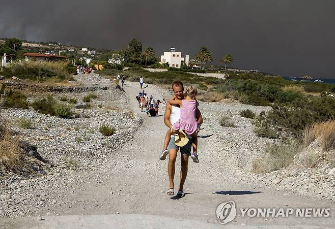 검은 연기를 뒤로하고 대피하는 남성 [AP 연합뉴스 자료사진. 재판매 및 DB 금지]